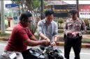 Kasat Intelkam Polres Langkat AKP Muliono memasang bendera merah putih di kendaraan warga.